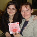 Two smiling ELI students. One is holding up a homemade Valentine's Day card.